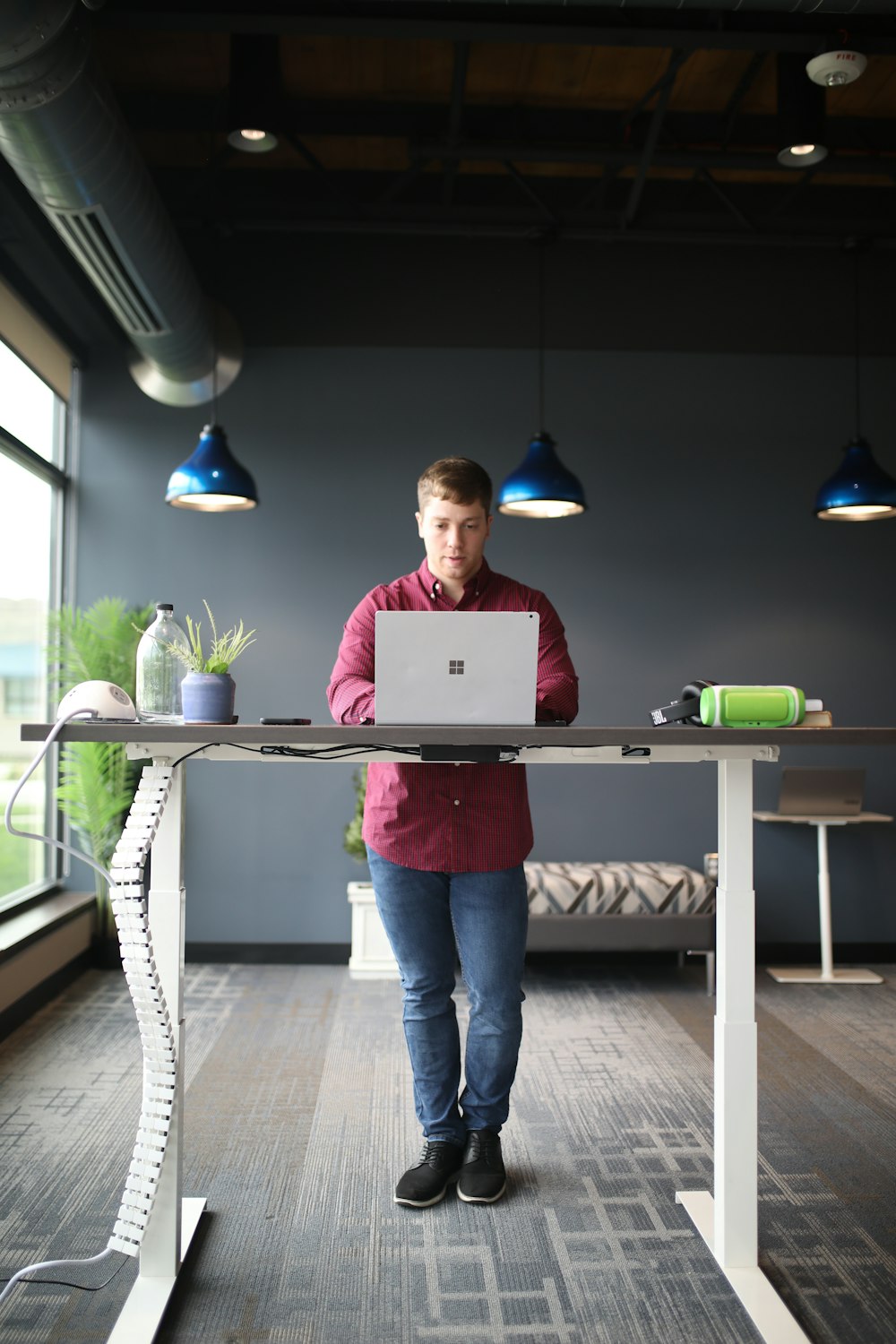 Un uomo in piedi davanti a un computer portatile