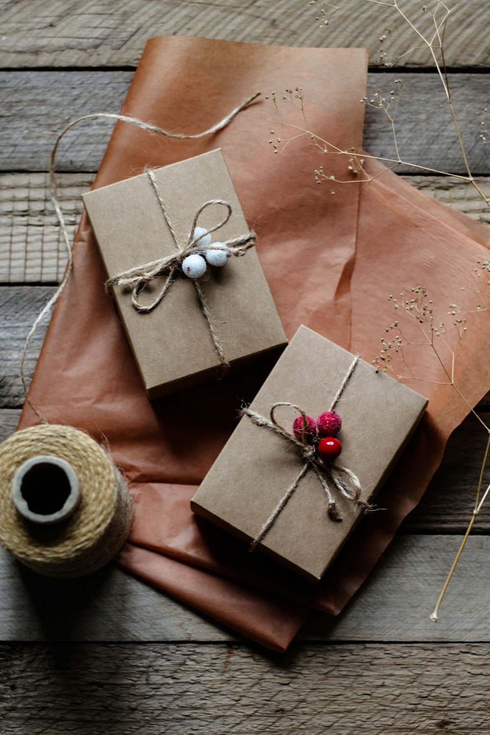 two wrapped presents sitting on top of a wooden table