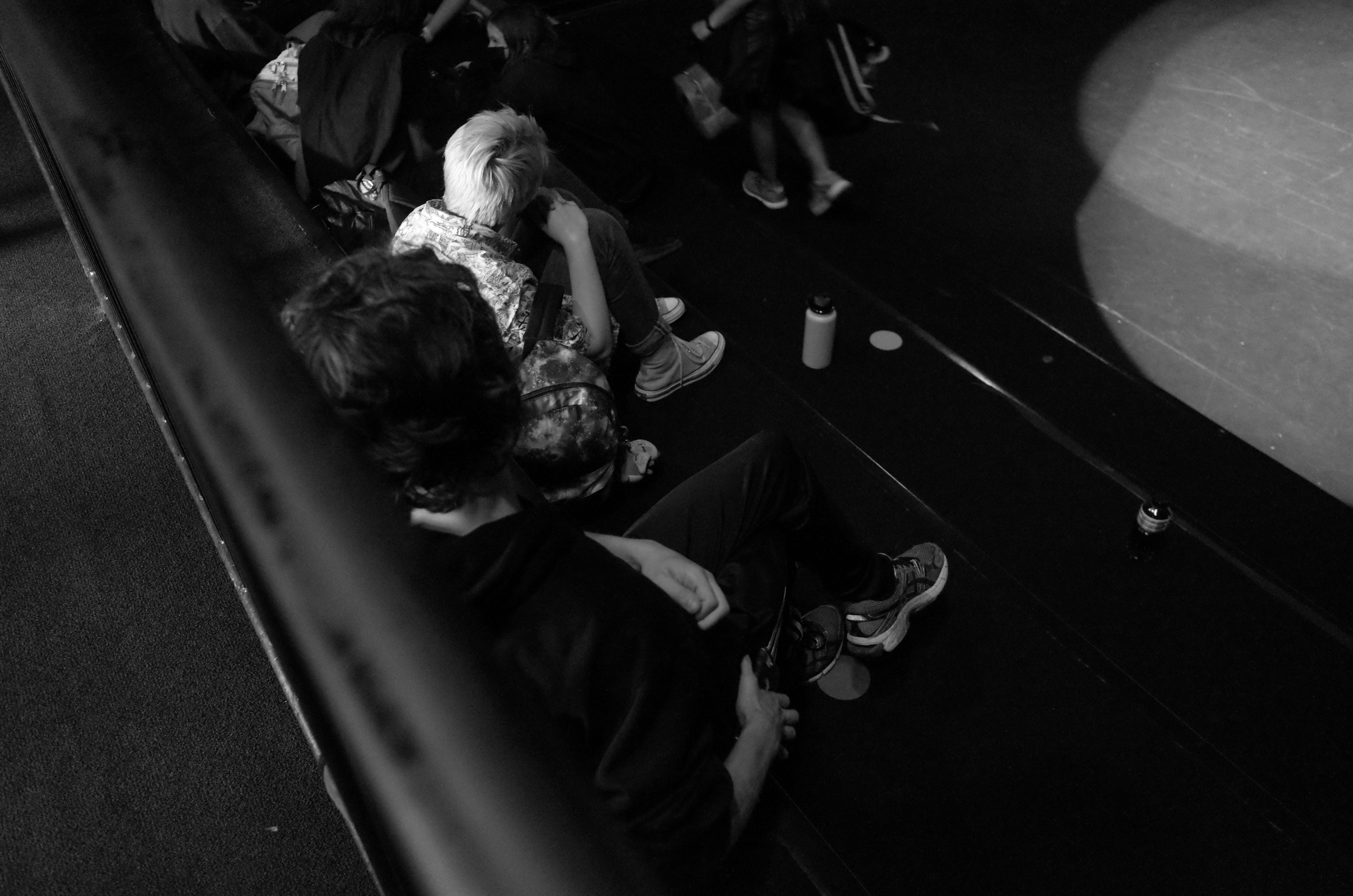 a group of people sitting on the ground next to each other