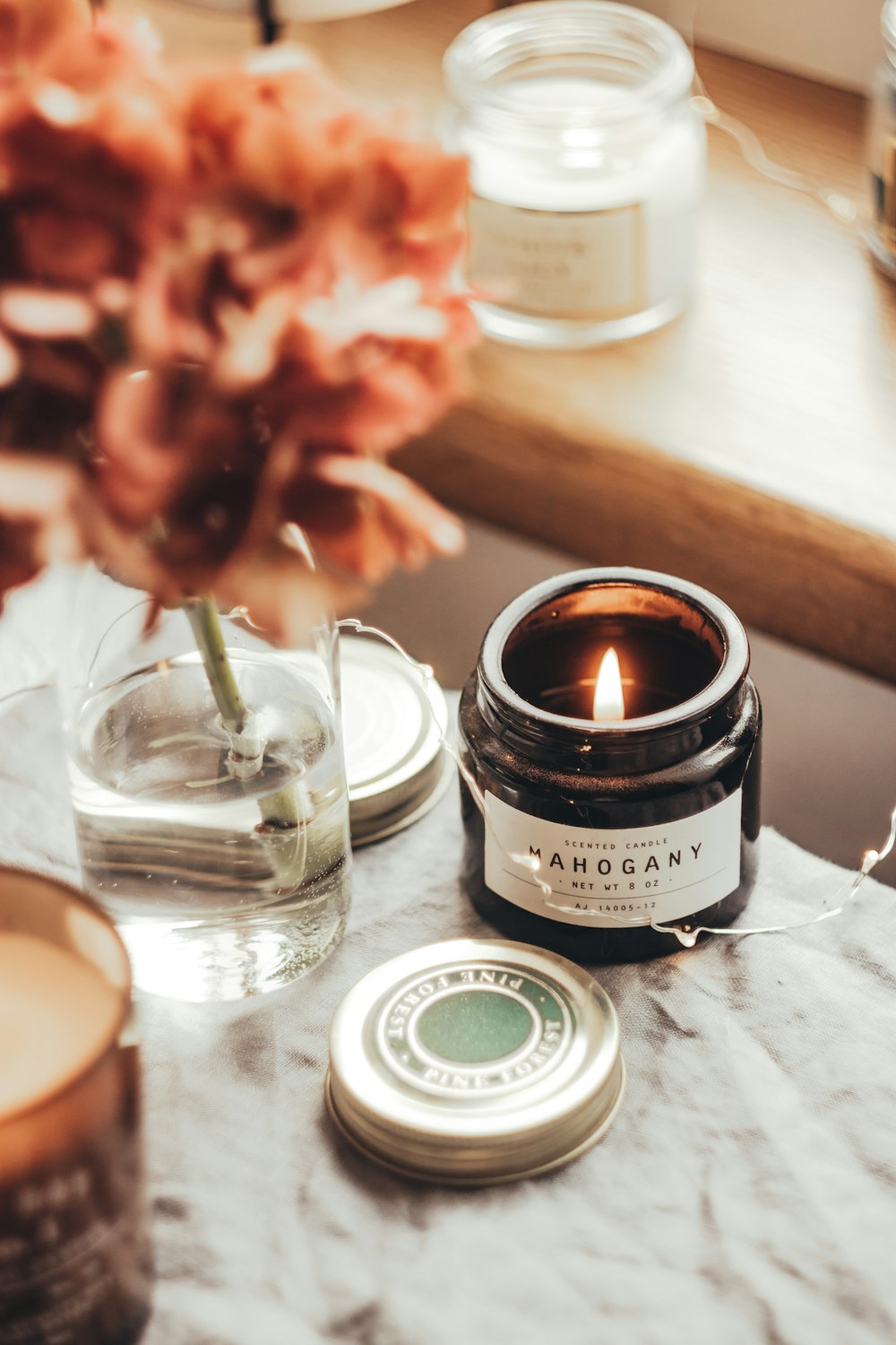 a candle sitting on top of a table next to a vase of flowers