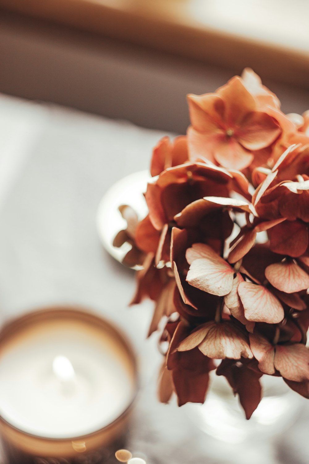 a vase filled with flowers next to a candle