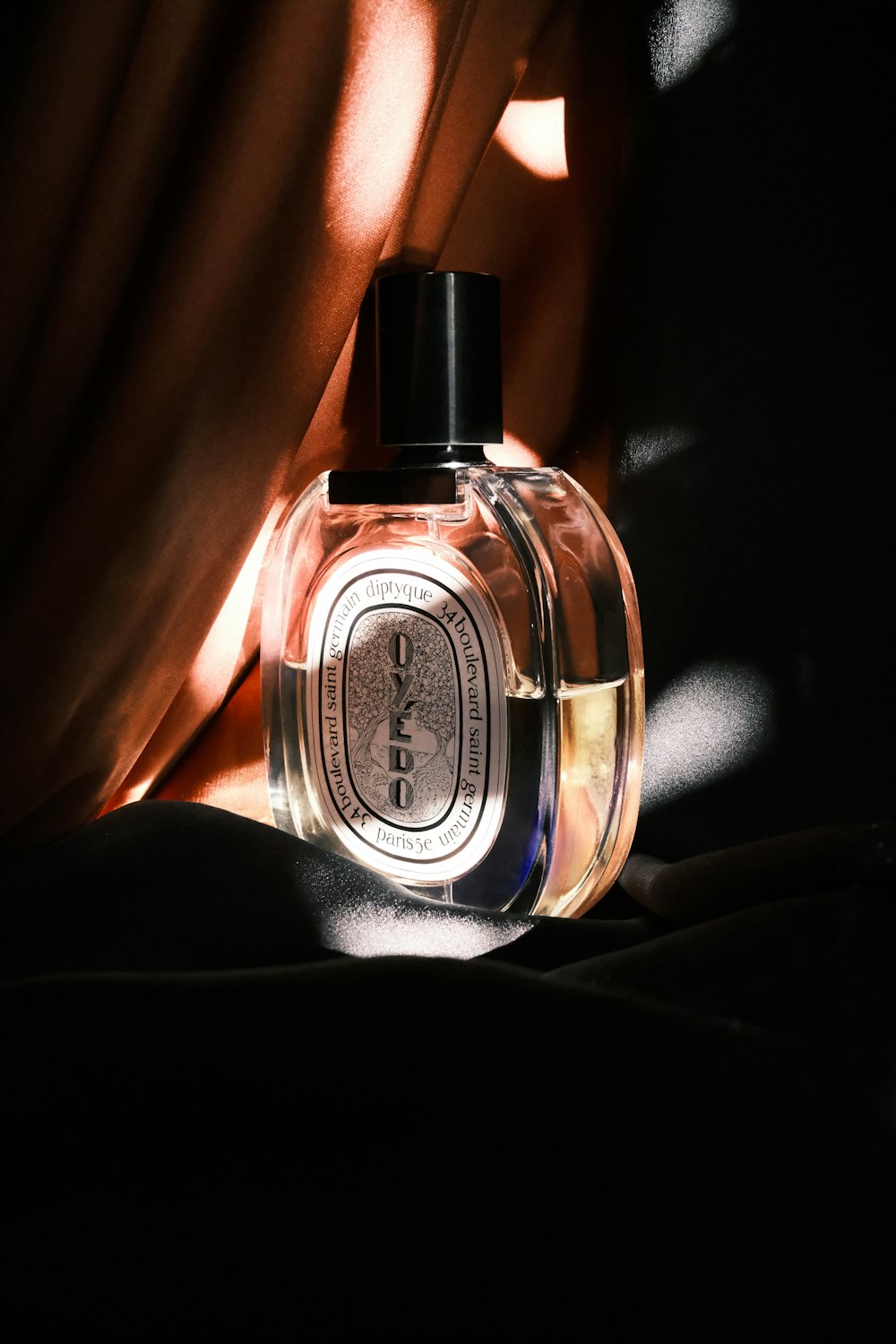 a bottle of perfume sitting on top of a bed