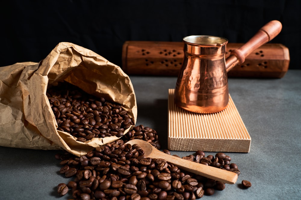 Una bolsa de granos de café junto a un molinillo de café