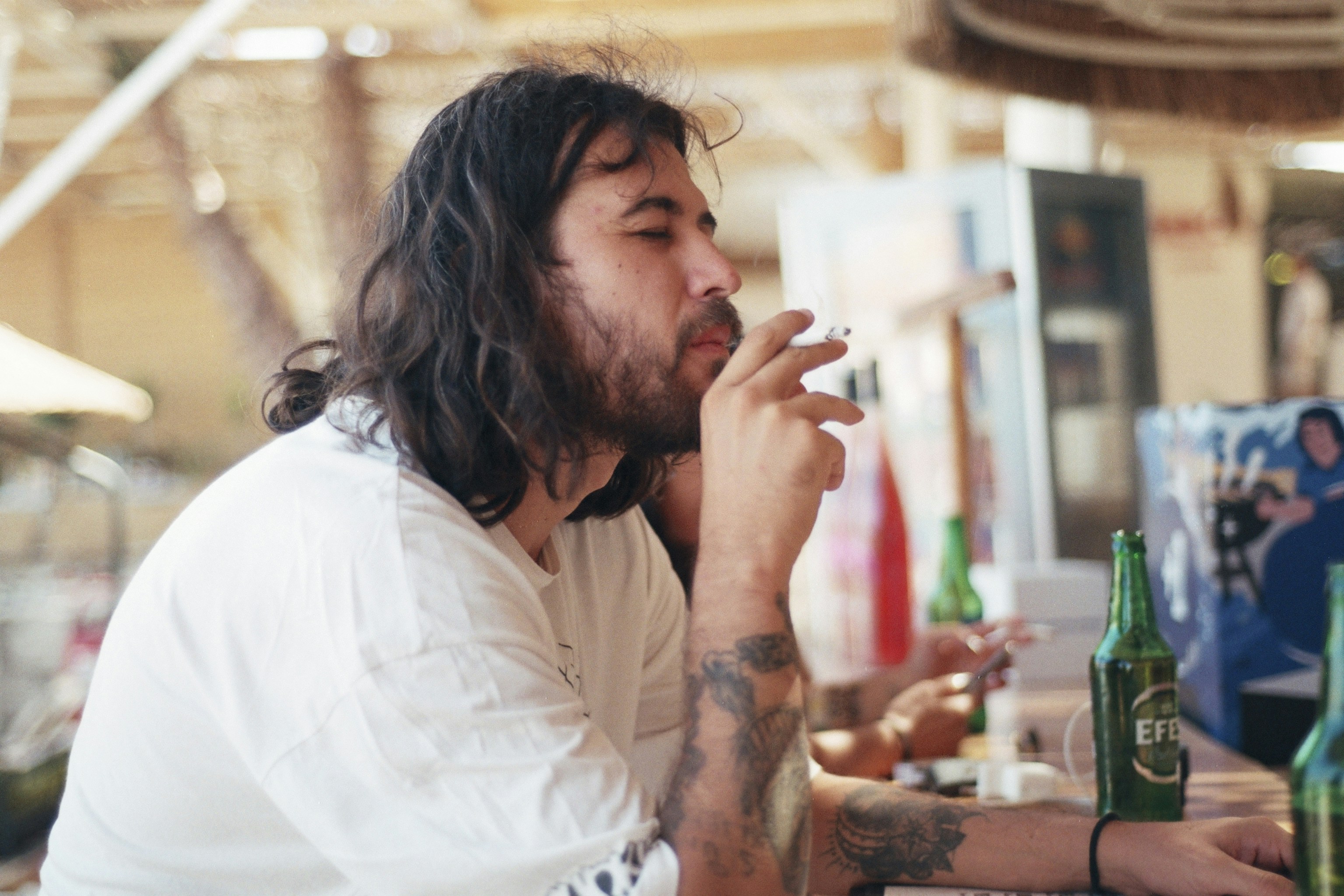 a man sitting at a bar smoking a cigarette