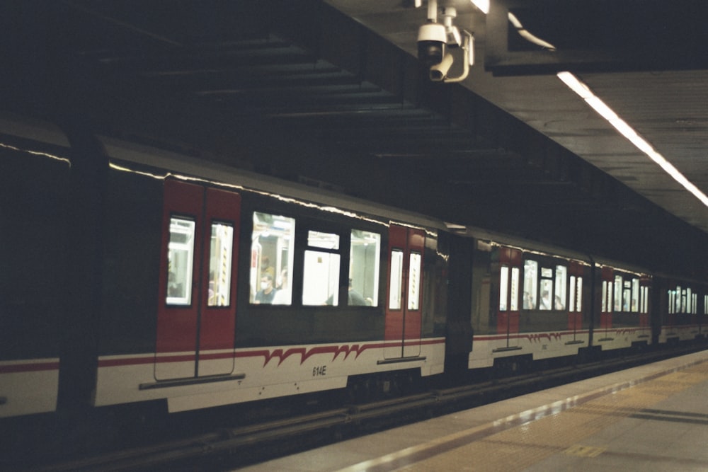 a red and white train pulling into a train station