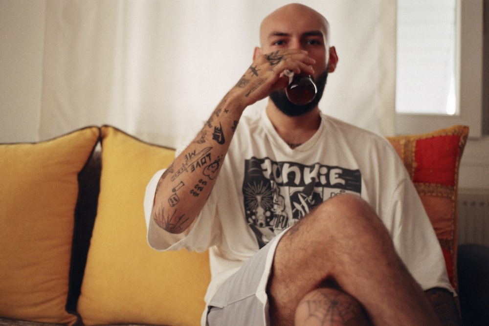 a man sitting on a couch drinking a beer