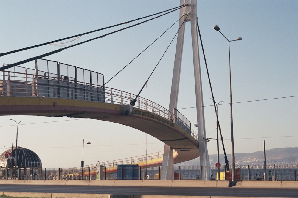 a bridge over a road with a train on it