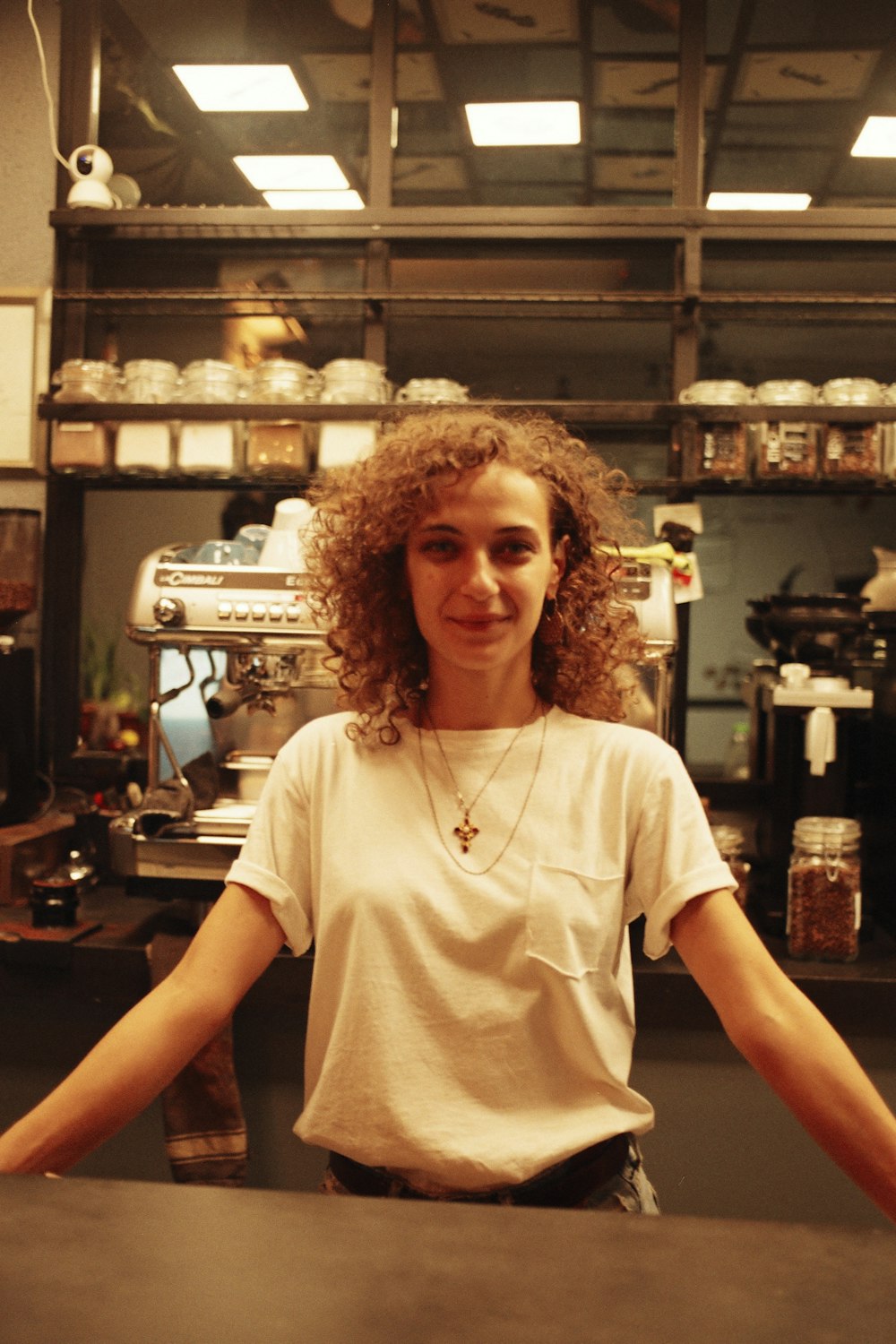 a woman standing behind a counter in a kitchen