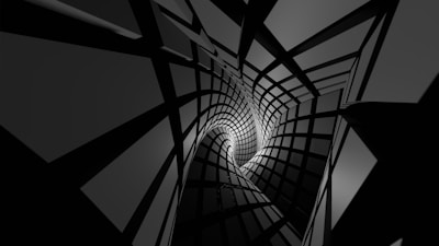 A dynamic abstract design featuring a twisting tunnel of black and white geometric shapes, creating a sense of depth and perspective.