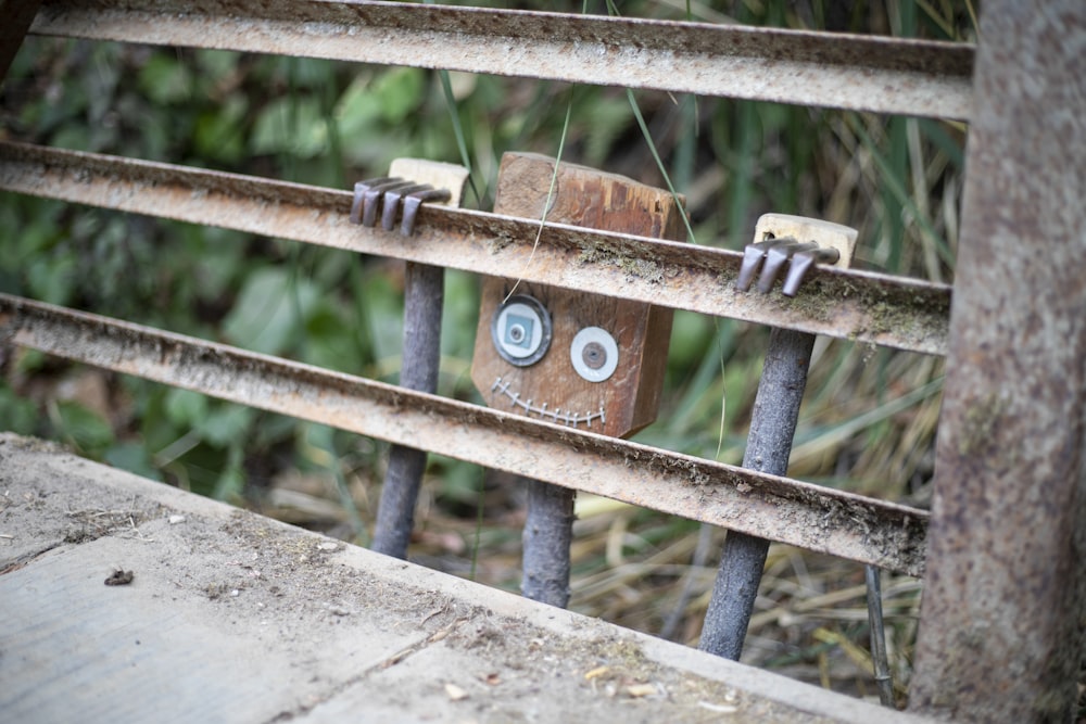 a close up of a metal fence with faces on it