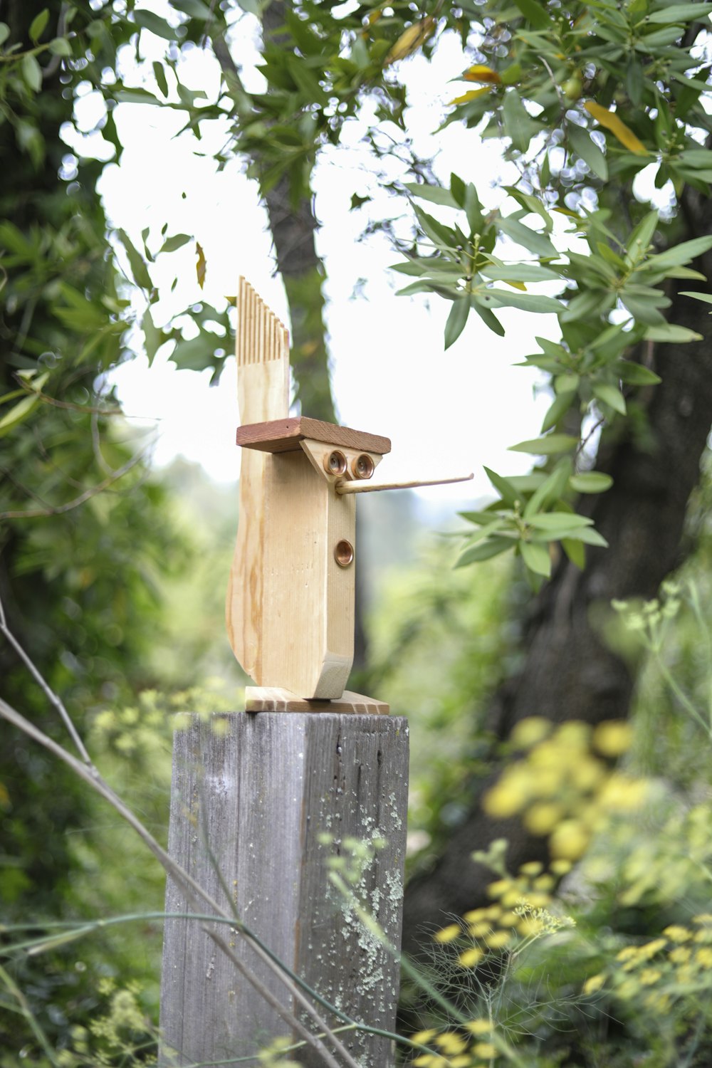 a wooden bird house sitting on top of a wooden post