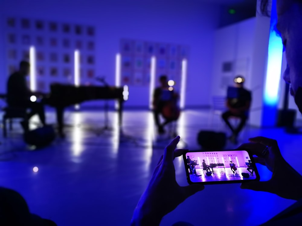 a person holding a cell phone in a dark room