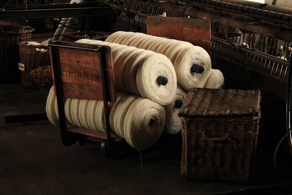 several rolls of yarn sitting on top of a wooden cart