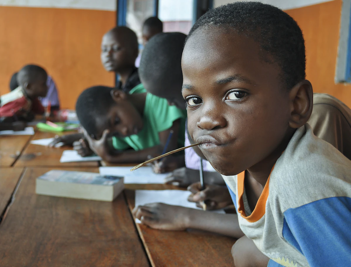 A student at a desk among classmates during a lesson