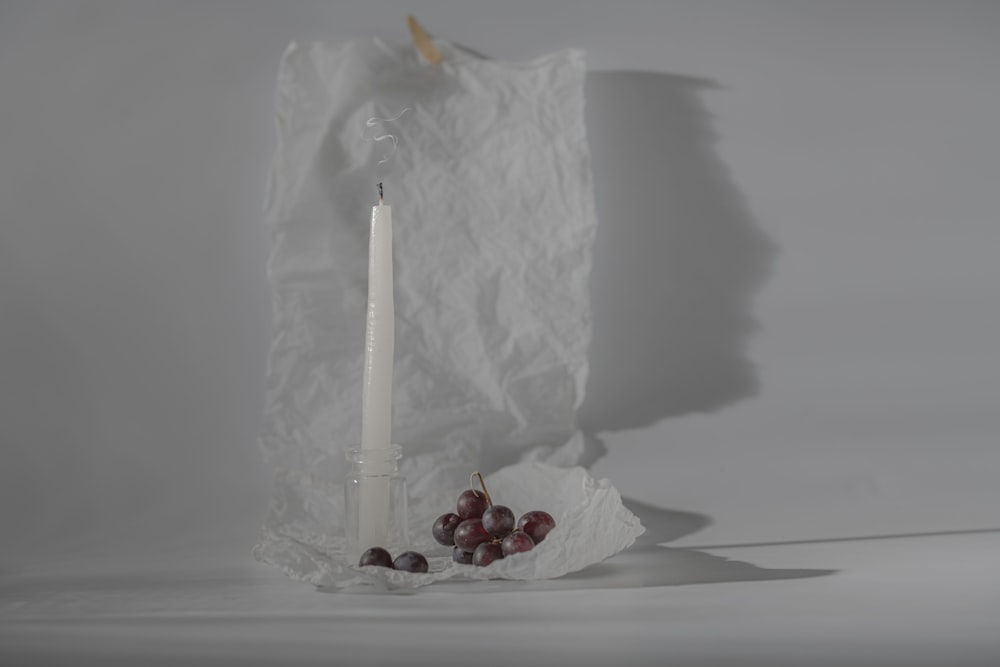 a candle and some grapes on a table