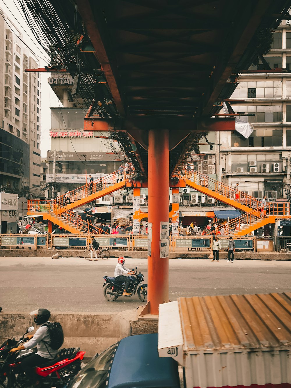 a man riding a motorcycle down a street next to tall buildings