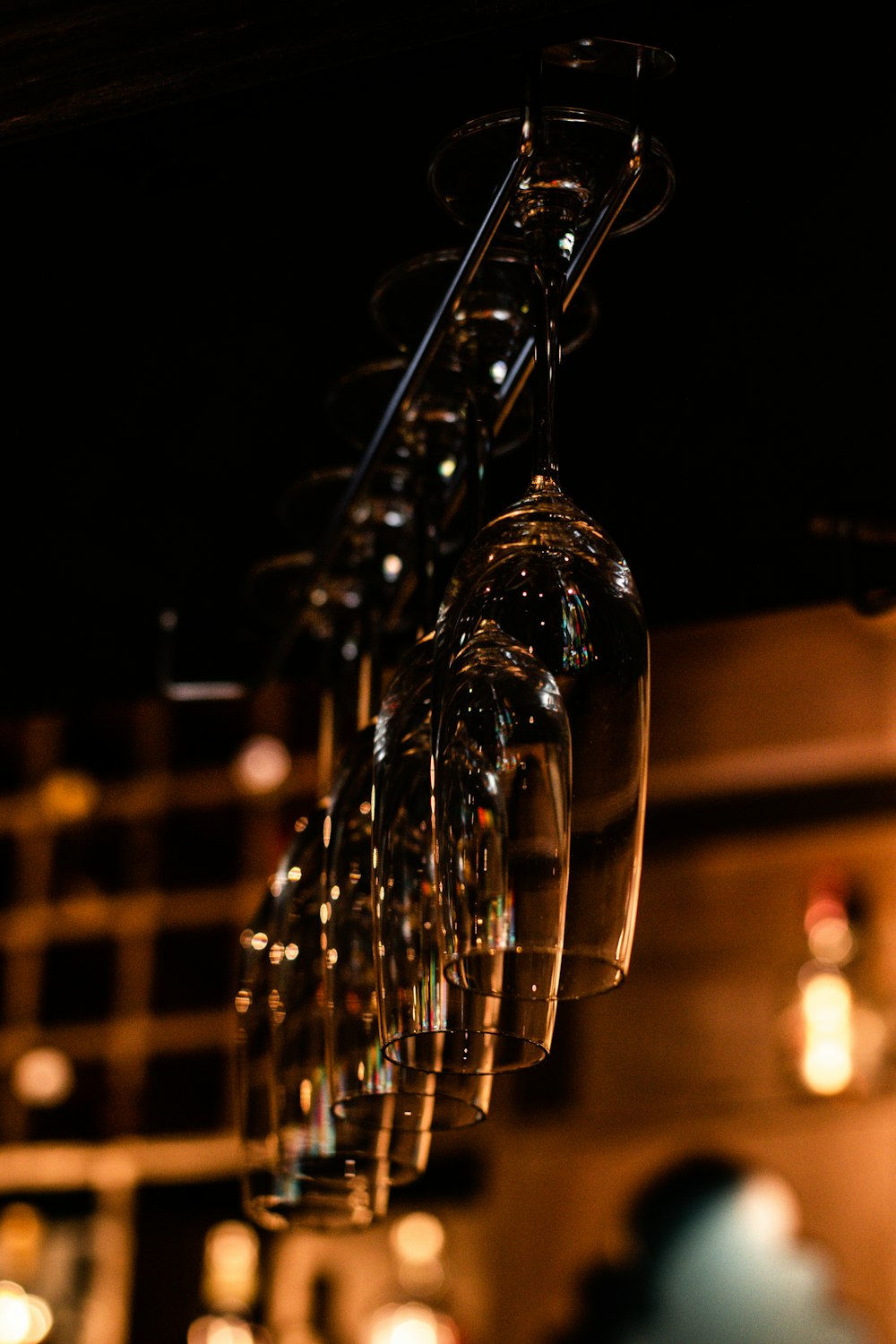 a bunch of wine glasses hanging from a rack