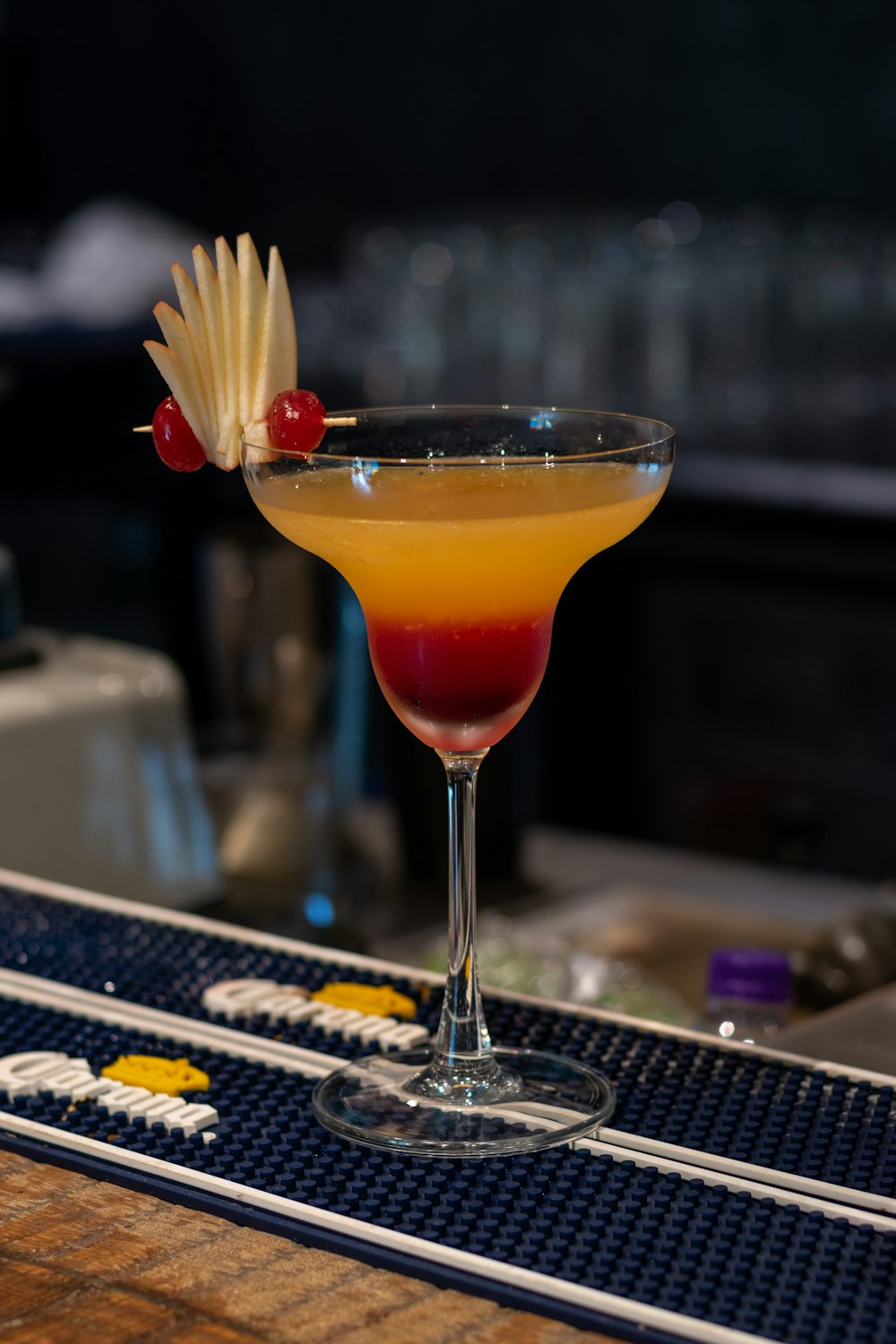 a cocktail with a pineapple garnish and a cherry garnish on