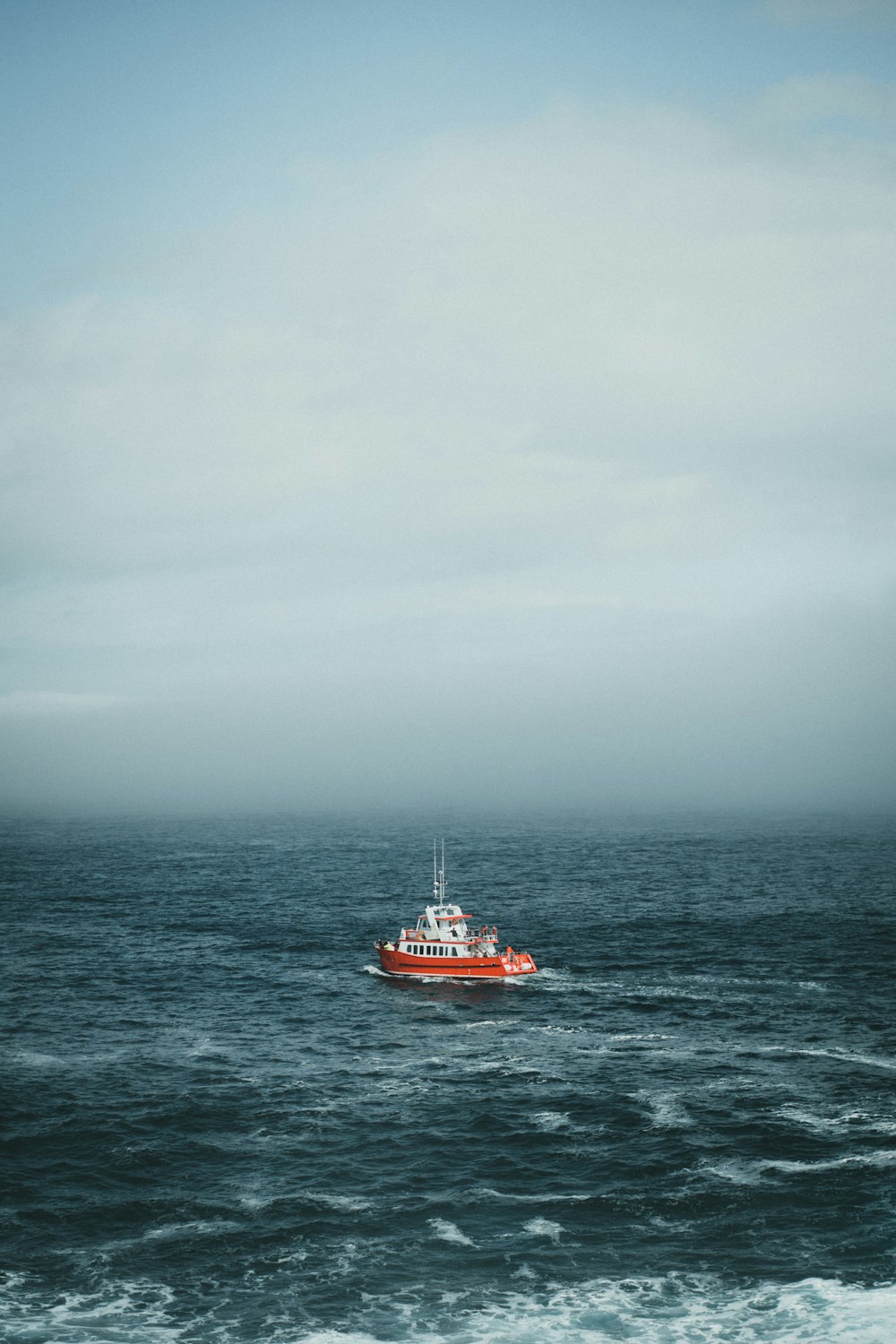 a red boat in the middle of the ocean