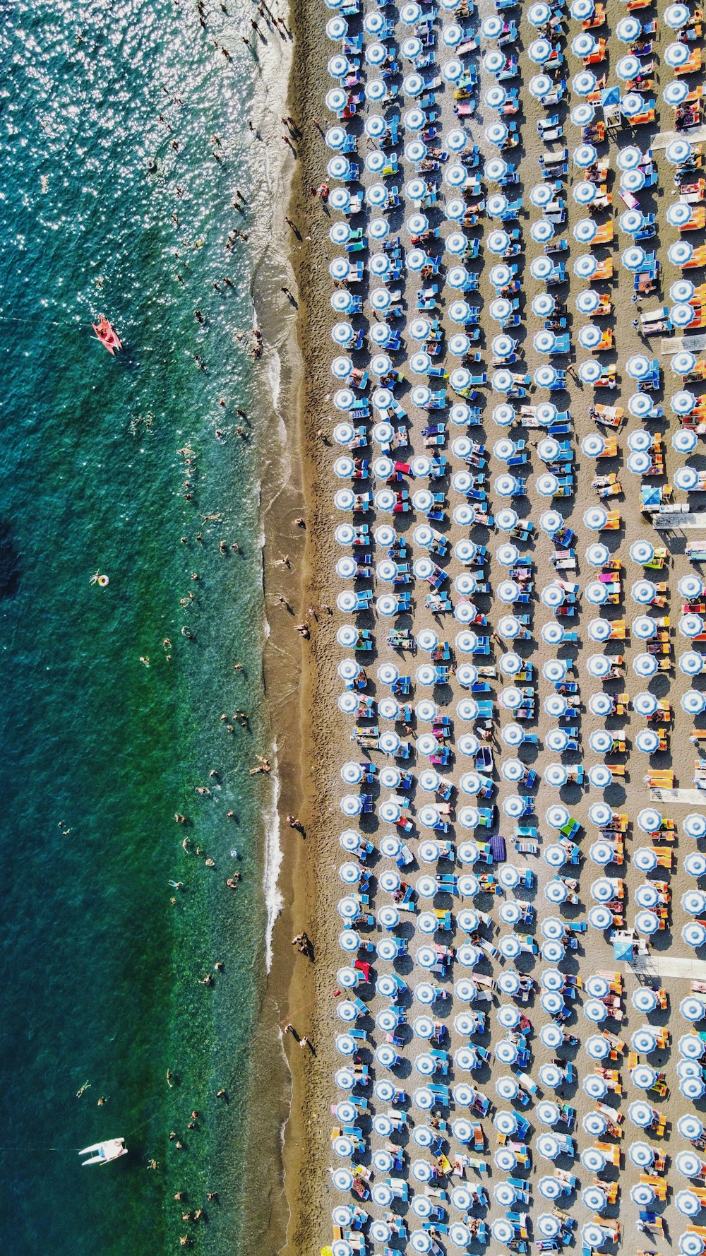 a beach filled with lots of umbrellas next to the ocean