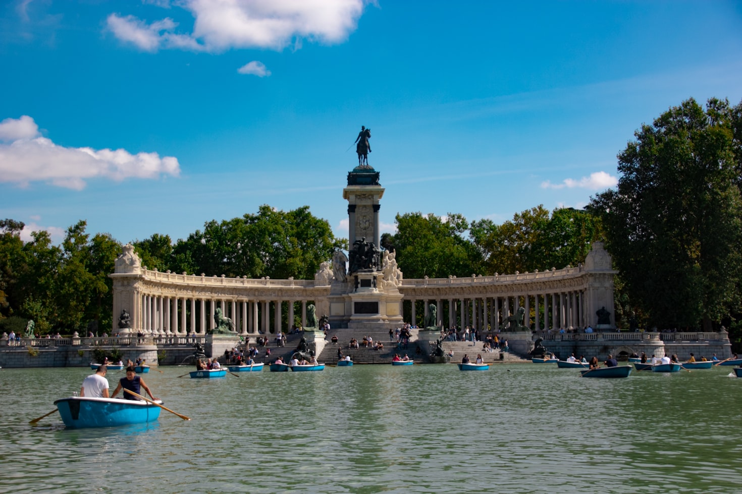 delle barche attraversano il lago artificiale del parco del retiro a Madrid in una giornata di sole