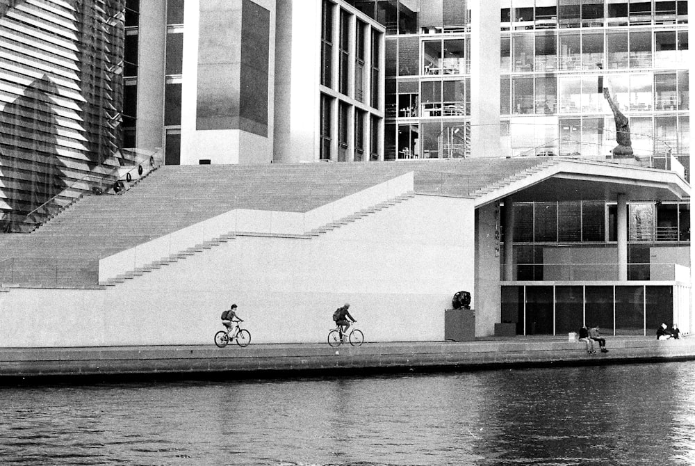 a black and white photo of people riding bikes