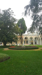 Lush green landscaped gardens with walking paths and seating areas for residents.