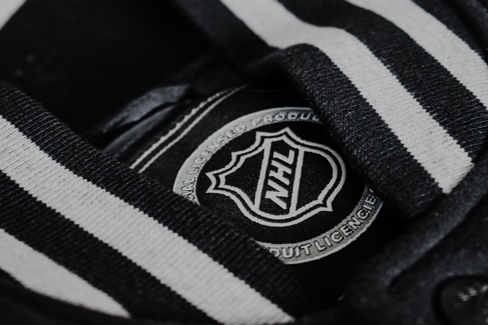 a black and white striped shirt with a badge on it