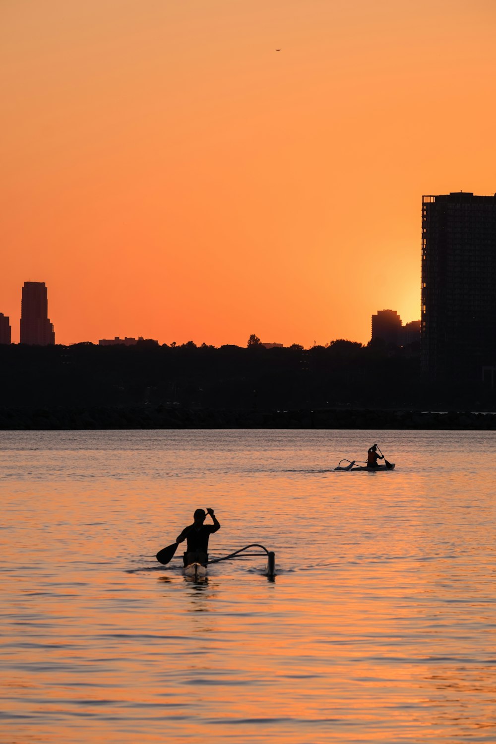 a person on a surfboard in the water at sunset