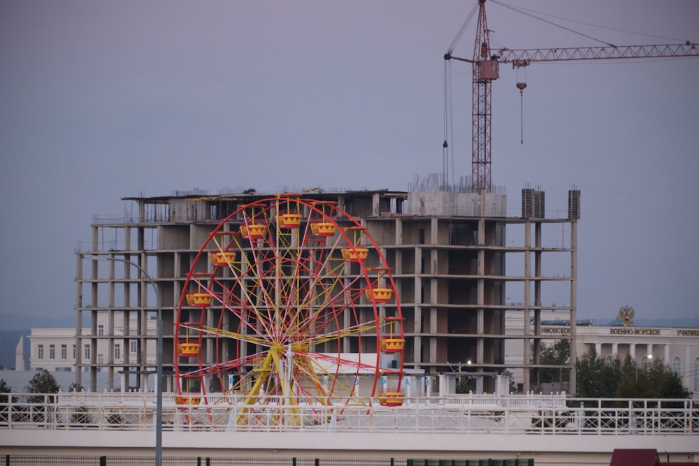 a ferris wheel in front of a building under construction