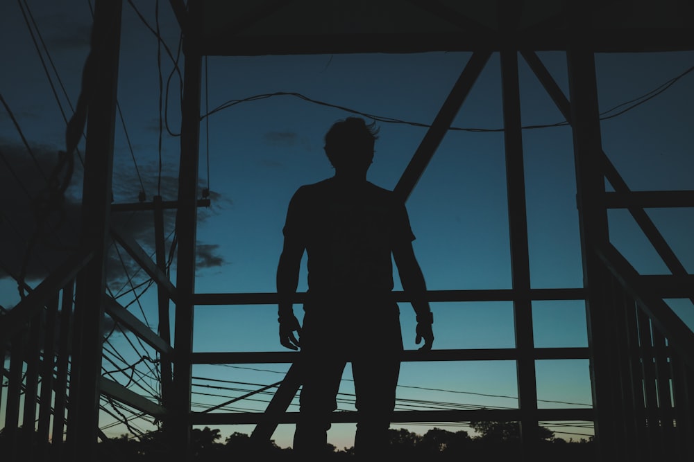 a man standing in front of a metal structure