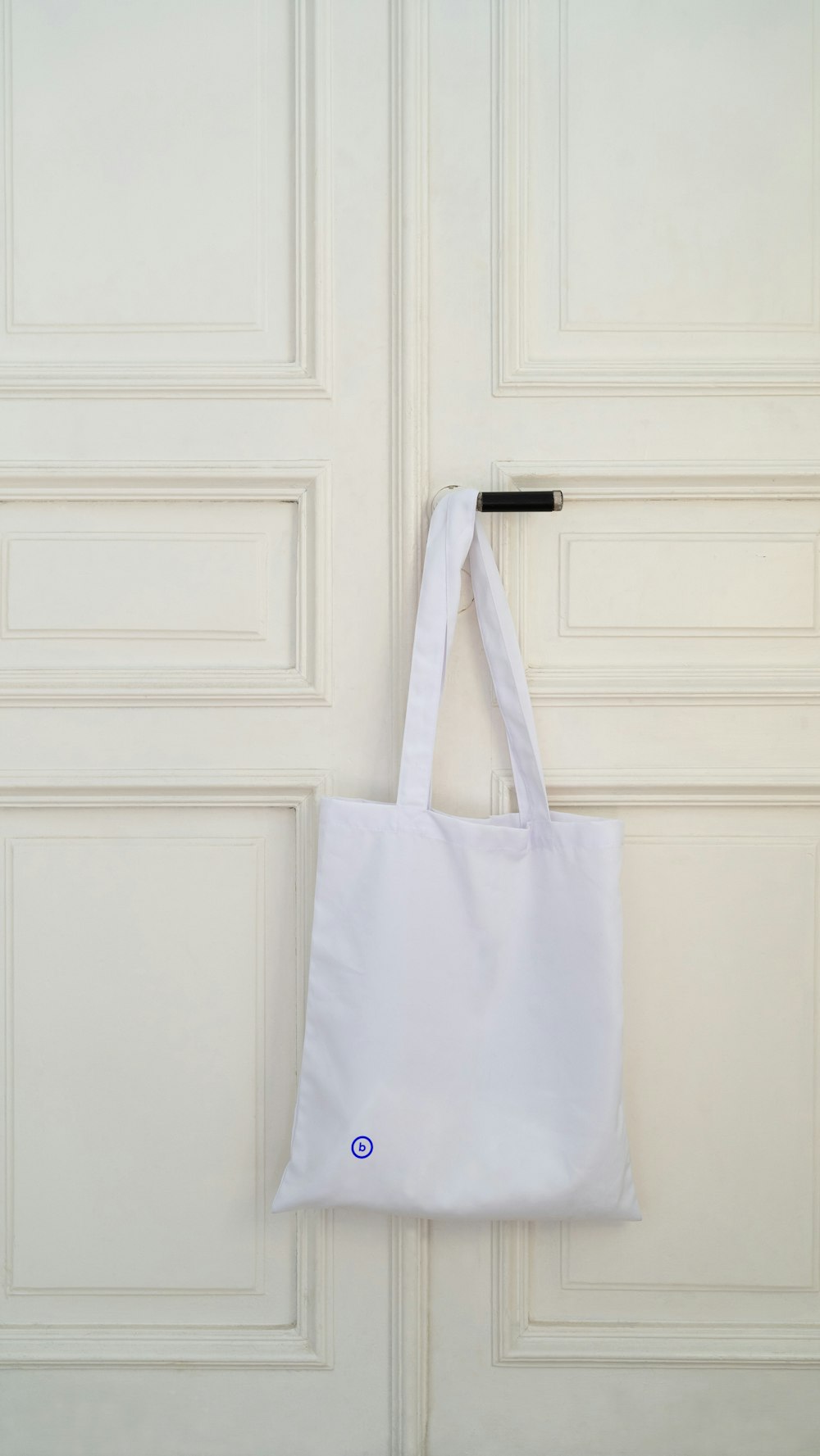 a white bag hanging on a white door