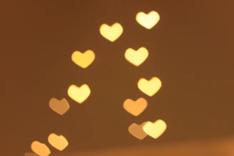 An elegant cluster of floating hearts made of warm white light particles, drifting gently over a blurred boutique backdrop.