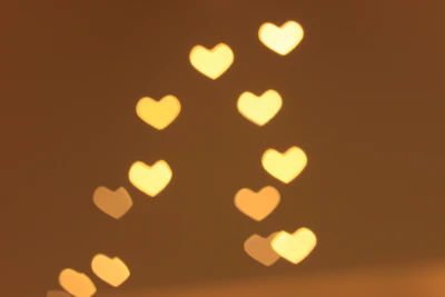 An elegant cluster of floating hearts made of warm white light particles, drifting gently over a blurred boutique backdrop.