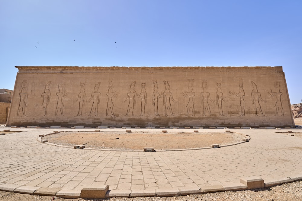 a large stone wall with statues on it