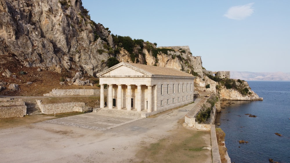 a large building sitting on top of a cliff next to the ocean