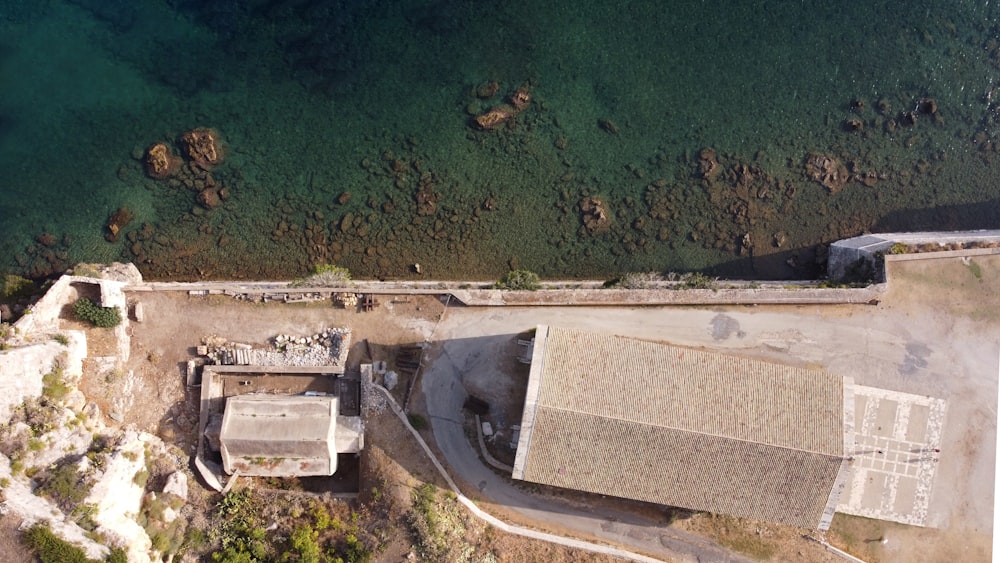 an aerial view of a building next to a body of water