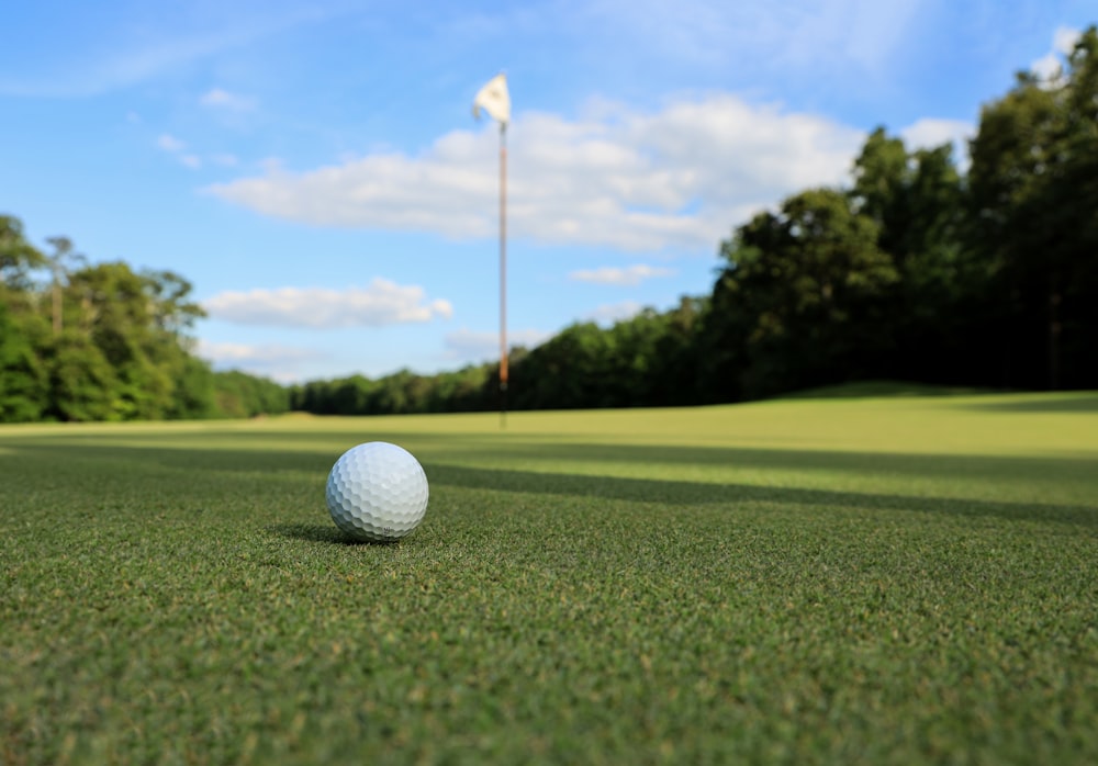 Una pelota de golf sentada en la parte superior de un campo verde