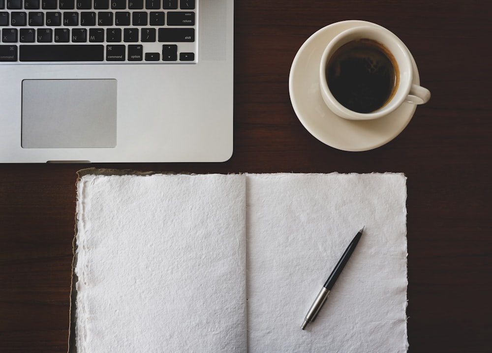 una taza de café y un cuaderno en un escritorio