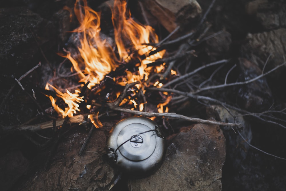 a white frisbee sitting on top of a rock next to a fire
