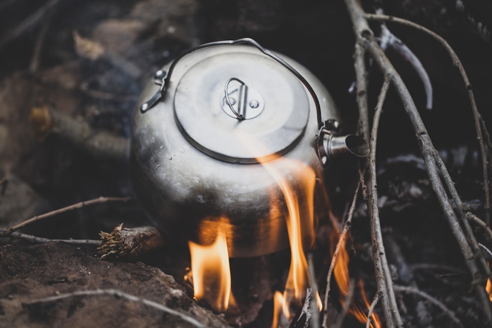 a tea pot is on fire in the woods