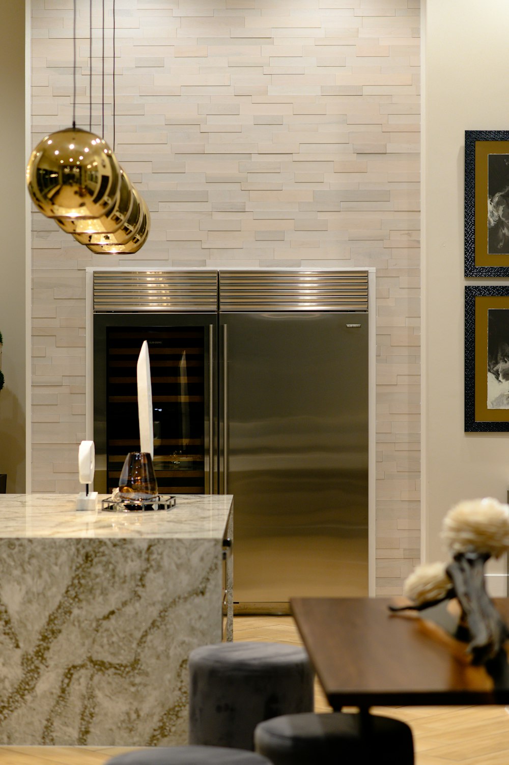 a modern kitchen with a marble island and stainless steel refrigerator