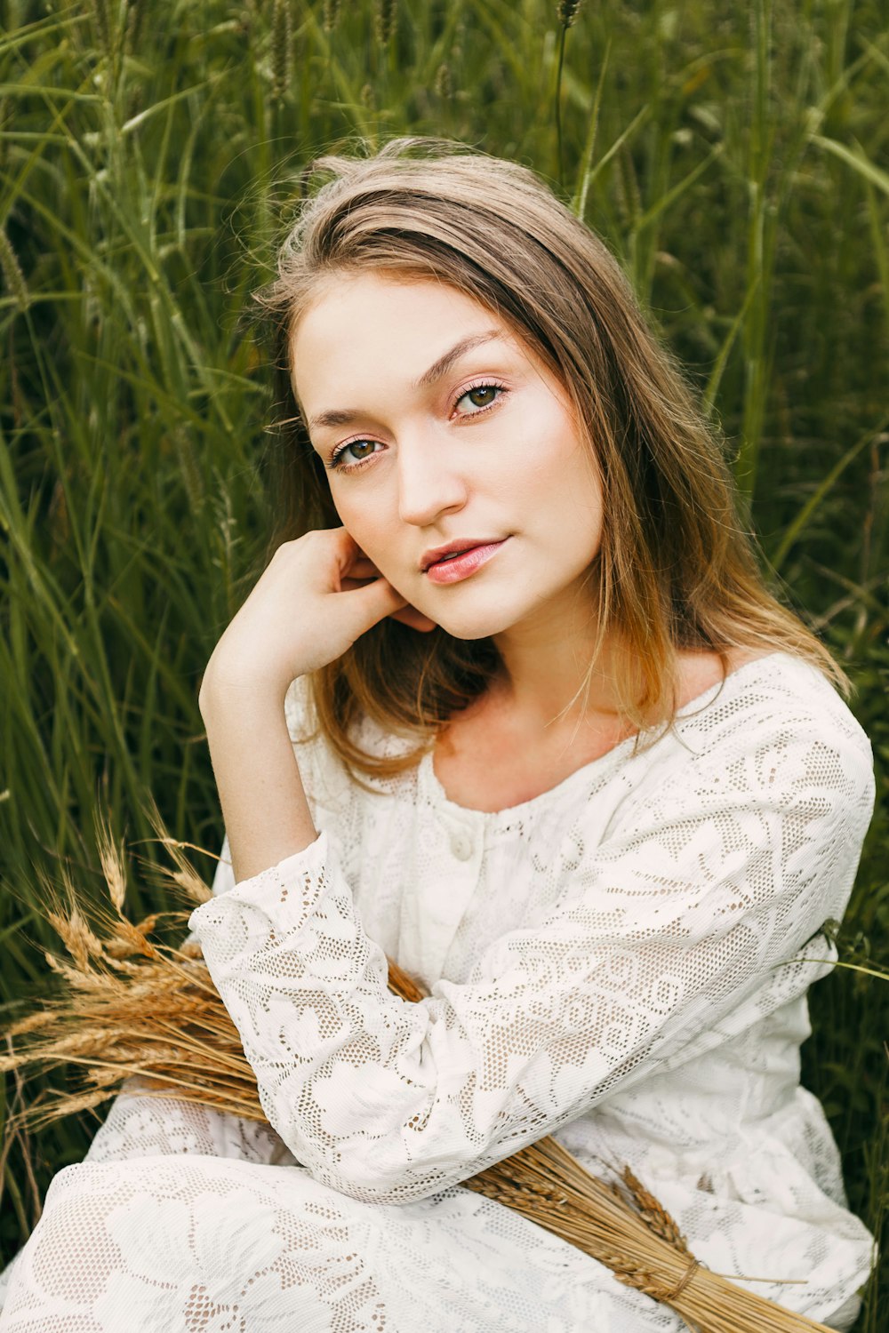 a woman sitting in a field of tall grass