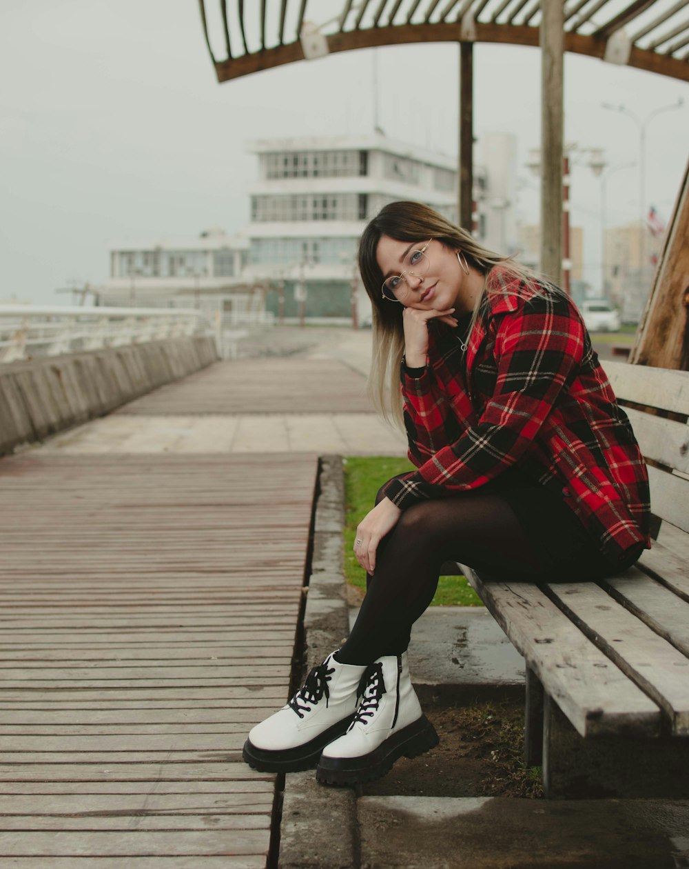 a woman sitting on top of a wooden bench