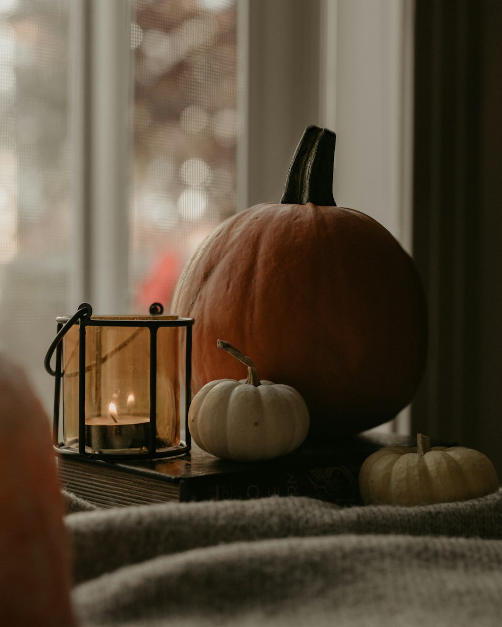 una vela y unas calabazas sobre una mesa