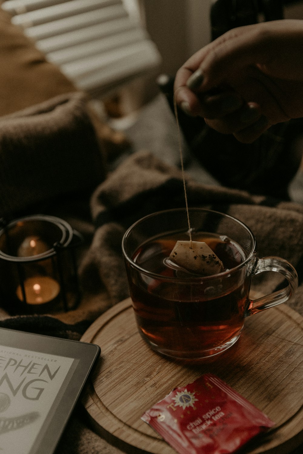 a person holding a spoon over a cup of tea