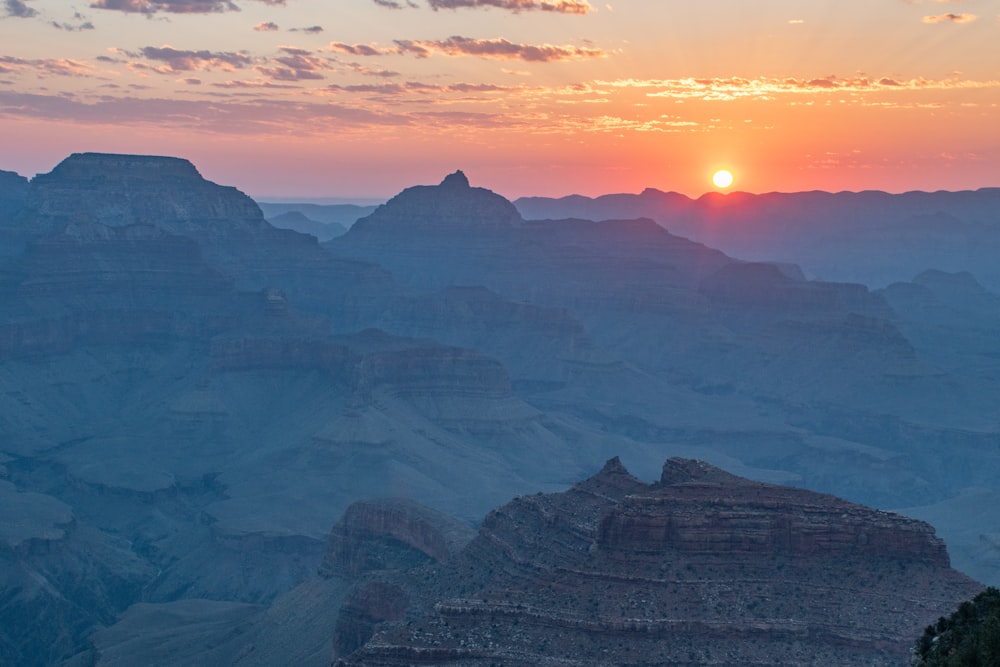 the sun is setting over the grand canyon