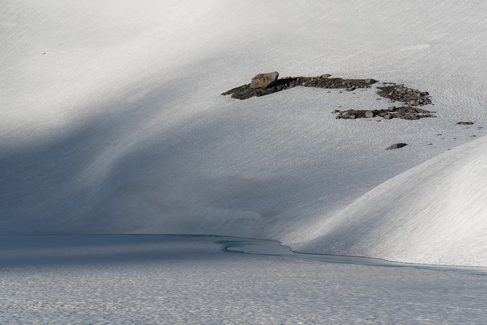 a snowboarder is going down a snowy hill