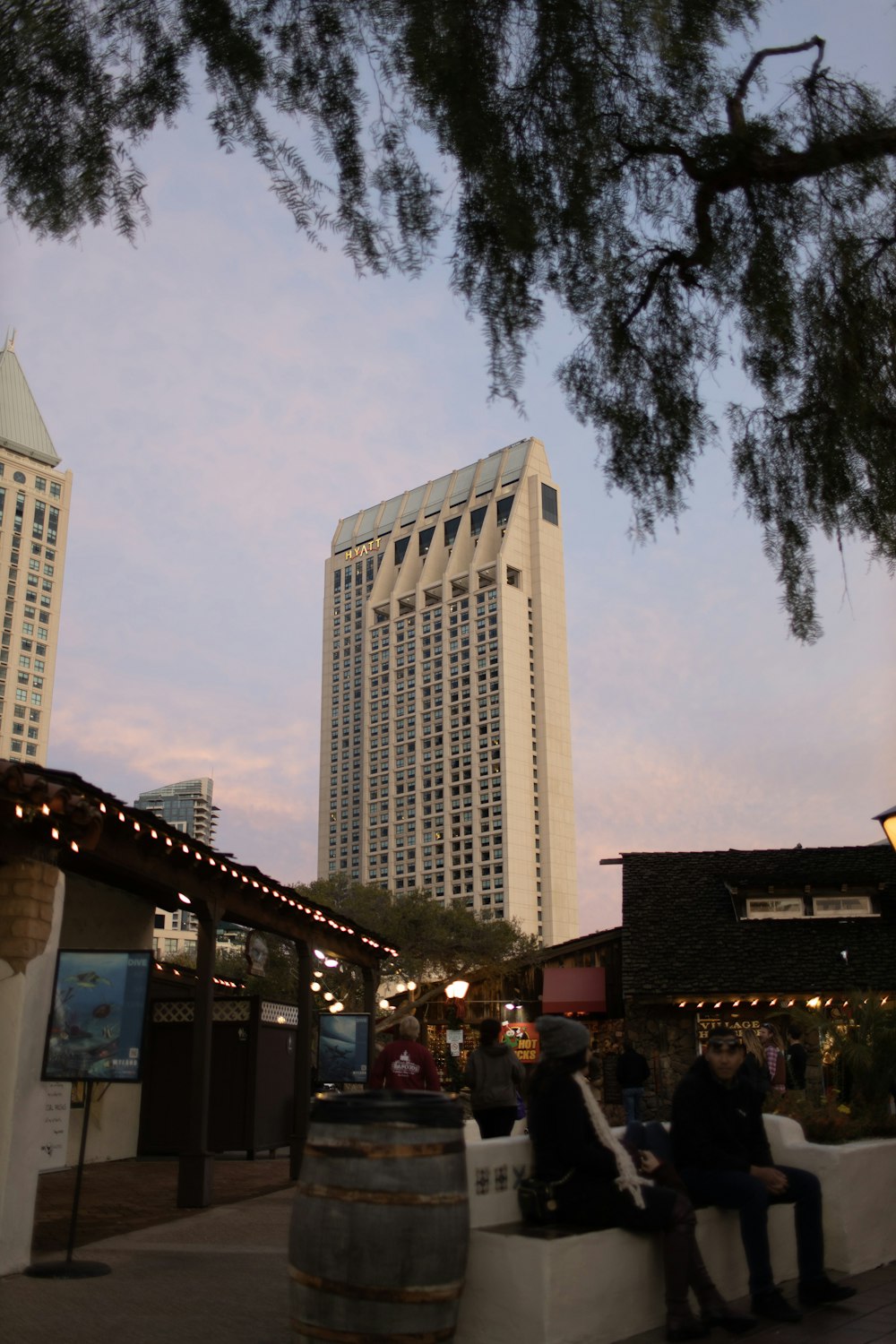 people sitting on a bench in front of a tall building