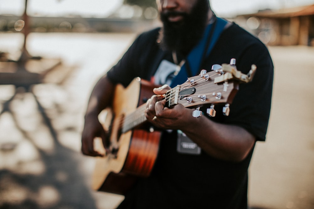 a man with a beard playing a guitar